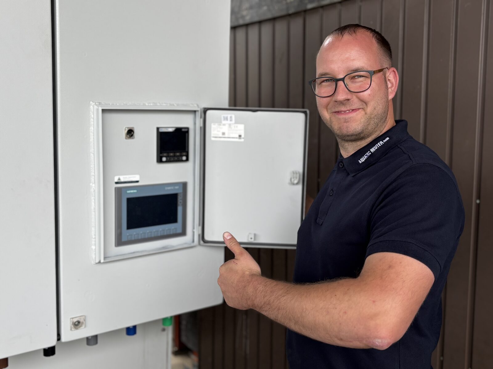 Aquatec-Reuter-Mitarbeiter am Schaltschrank mit HMI-Bedienpanel